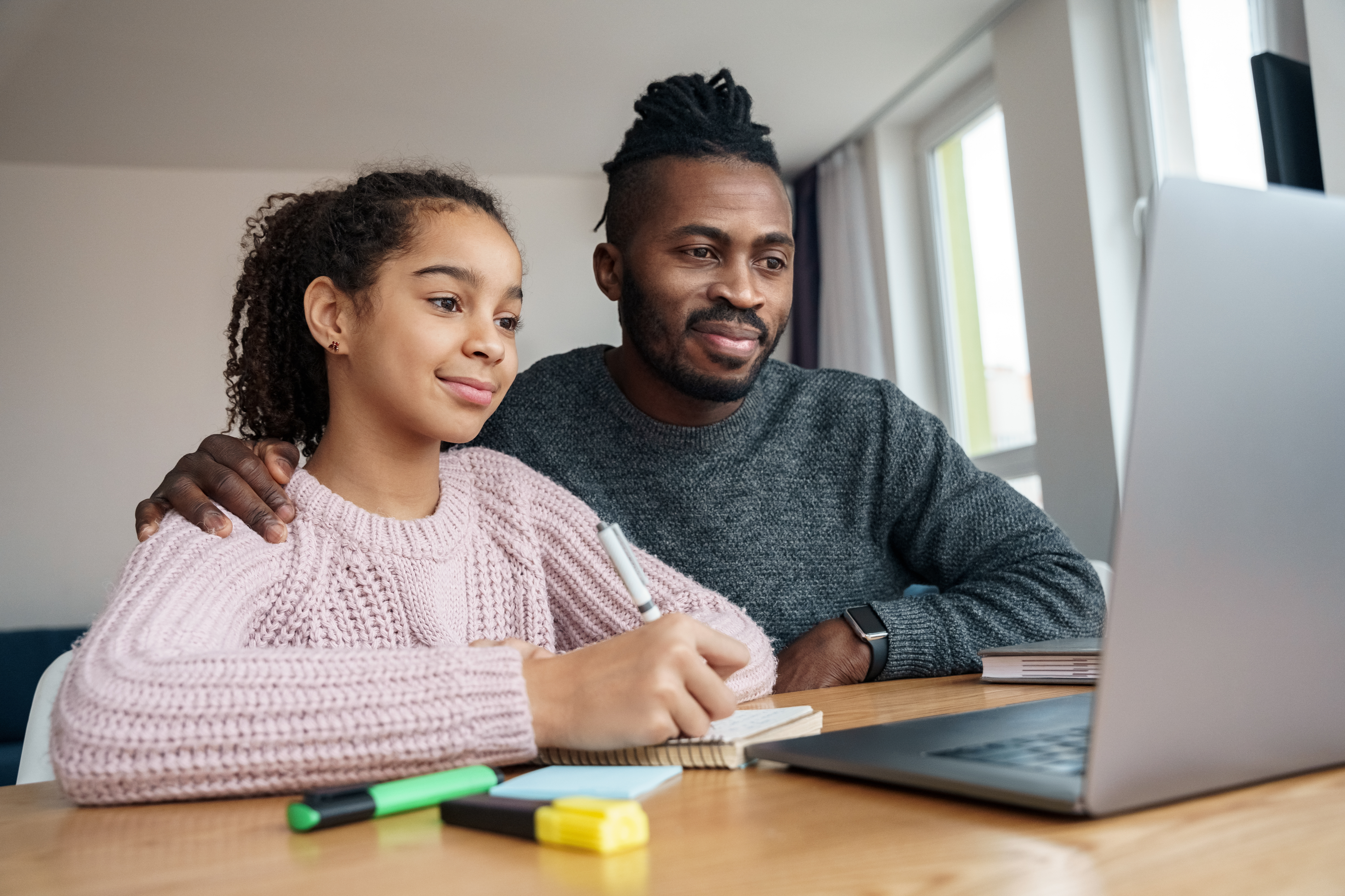 Father and daughter working together at a laptop