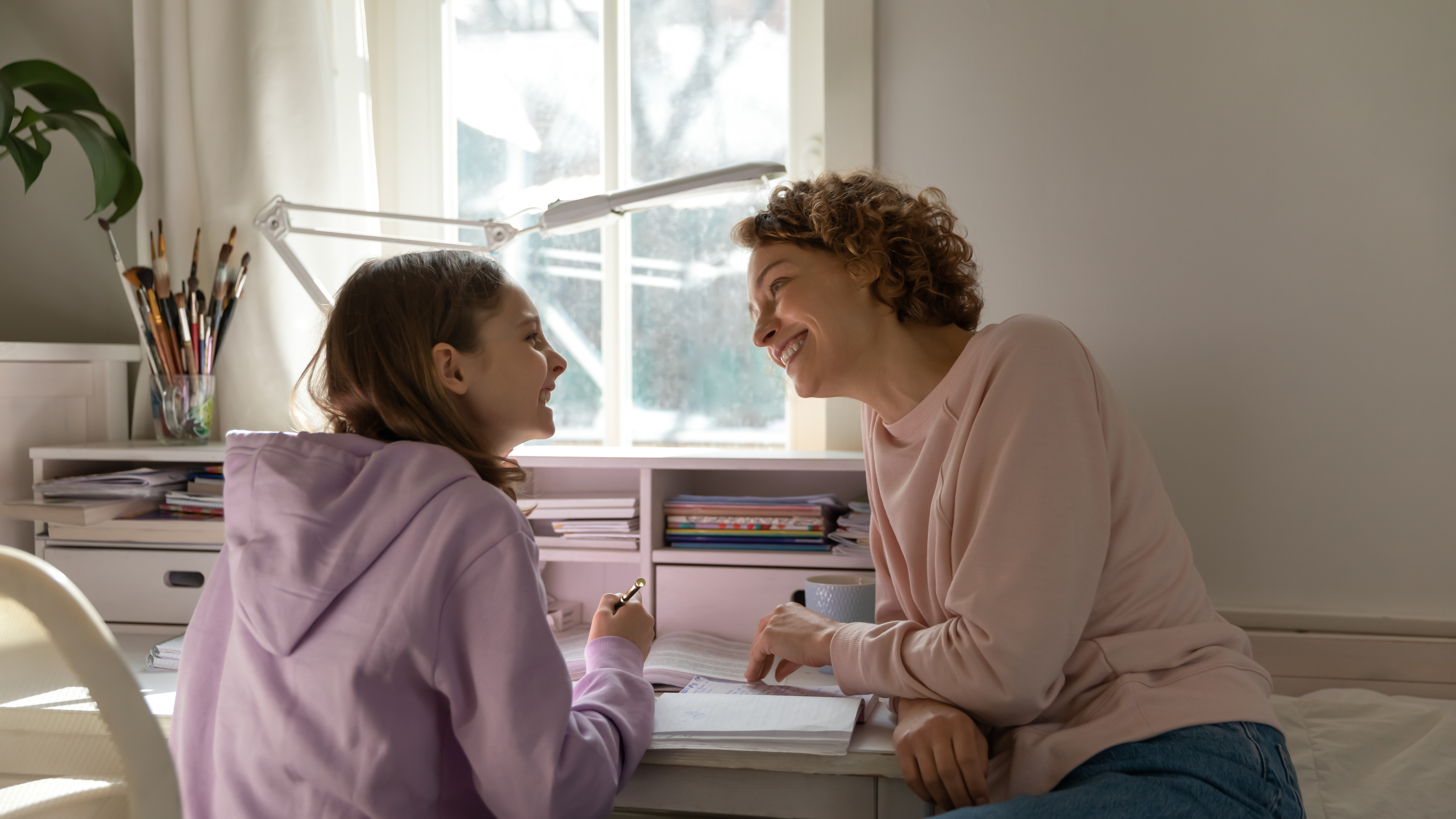 Mother and daughter laughing together while studying